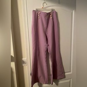 Flared pleated pants with pearl detail.